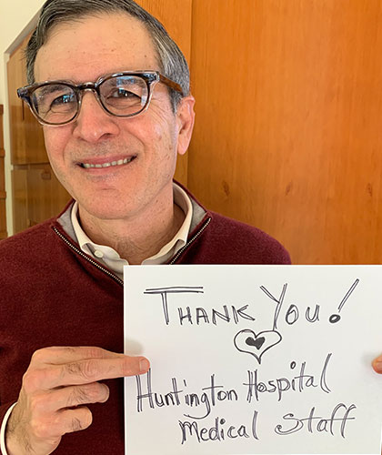 An older man holding a sign that reads Thank you! Huntington Hospital Medical Staff