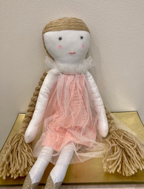 A stuffed doll in a pnk dress