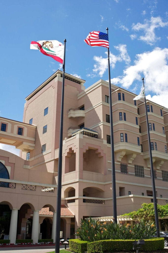 Flag poles in front of the Huntington Hospital with the California state flag and US flag in clear view