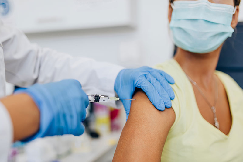 A physician giving administrating a flu shot to a patient