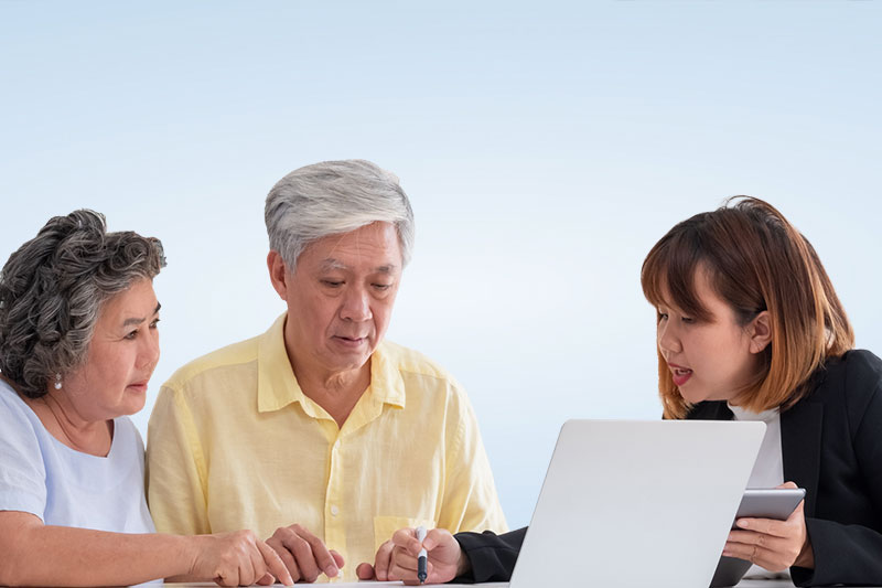 A younger woman helping an older couple understand a document