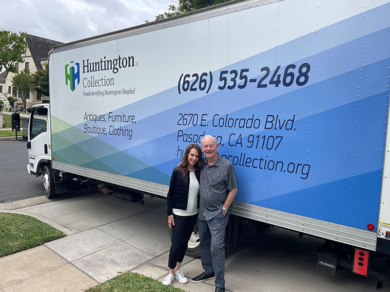 A couple stands in front of a Huntington Collection truck