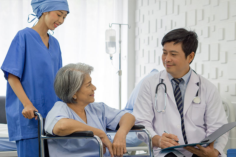 doctor talks to patient in wheelchair