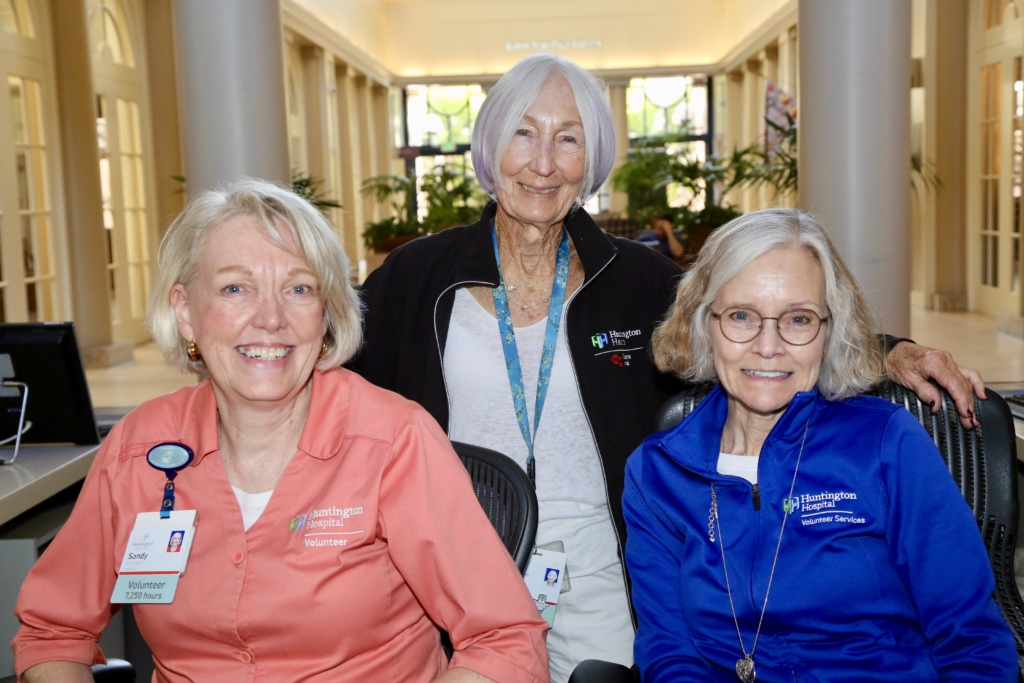 Three female volunteers at the information desk.