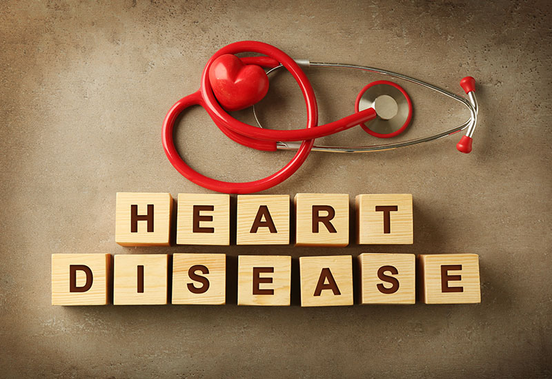 Red stethoscope with wooden blocks that spell out "Heart Disease"