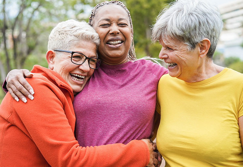 three senior women hugging