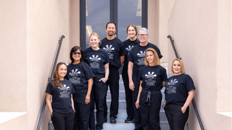 Group of 8 staff members standing on hospital stairs: Huntington Hospital’s Critical Care Unit Recognized with Beacon Award for Excellence