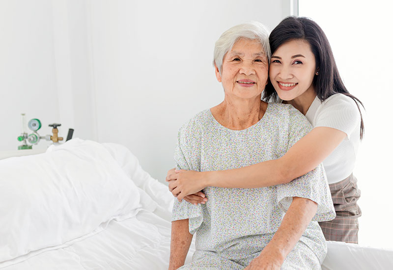 a young daughter or granddaughter hugging her grandmother