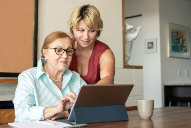 Two women looking at a laptop and one woman pointing to the screen