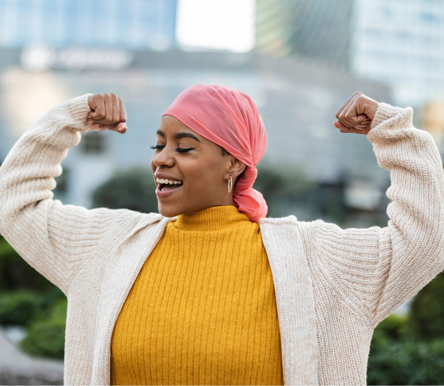 Smiling woman with hair scarf, holding both arms out, making muscles