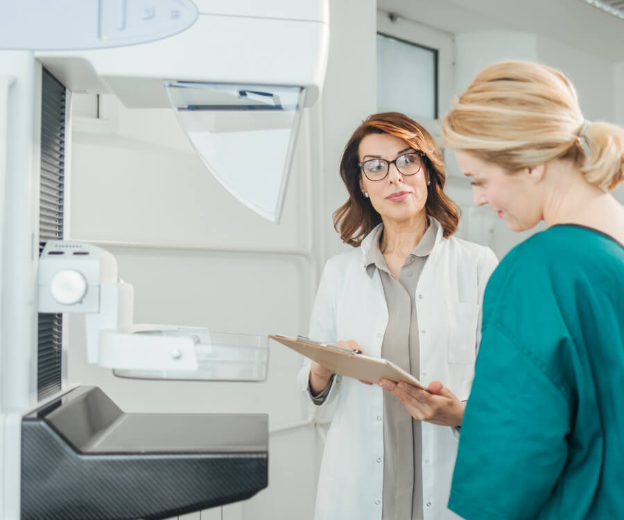 Nurse and patient in gown in mammogram room
