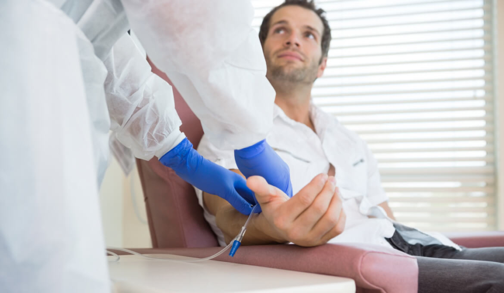 patient looking at nurse with rubber gloves with IV line