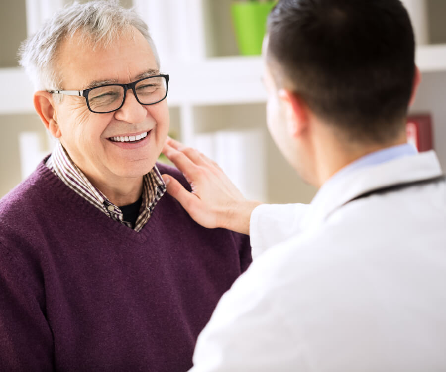 doctor puts hand on the shoulder of smiling patient